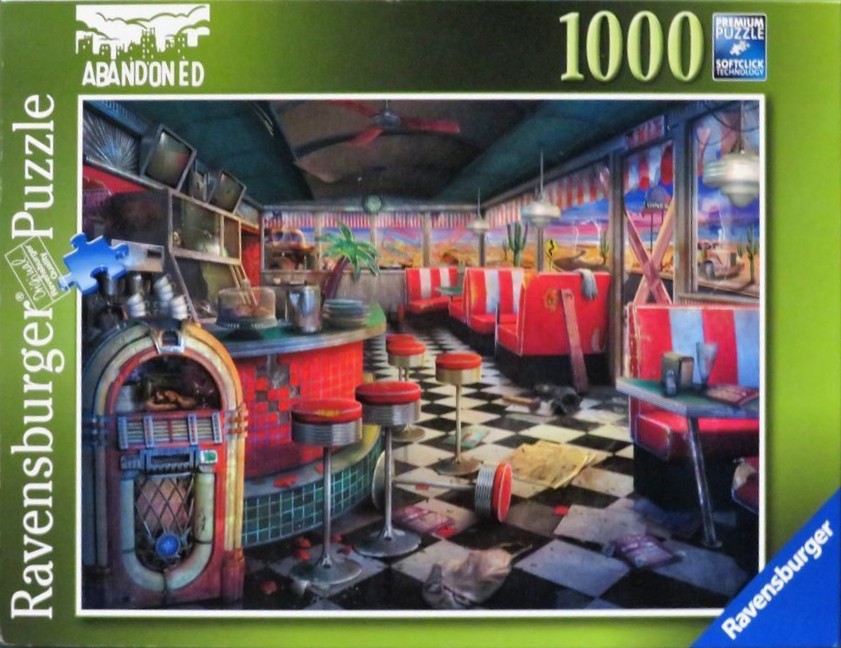 An abandoned 1950s style American diner with a jukebox and red booth seating.