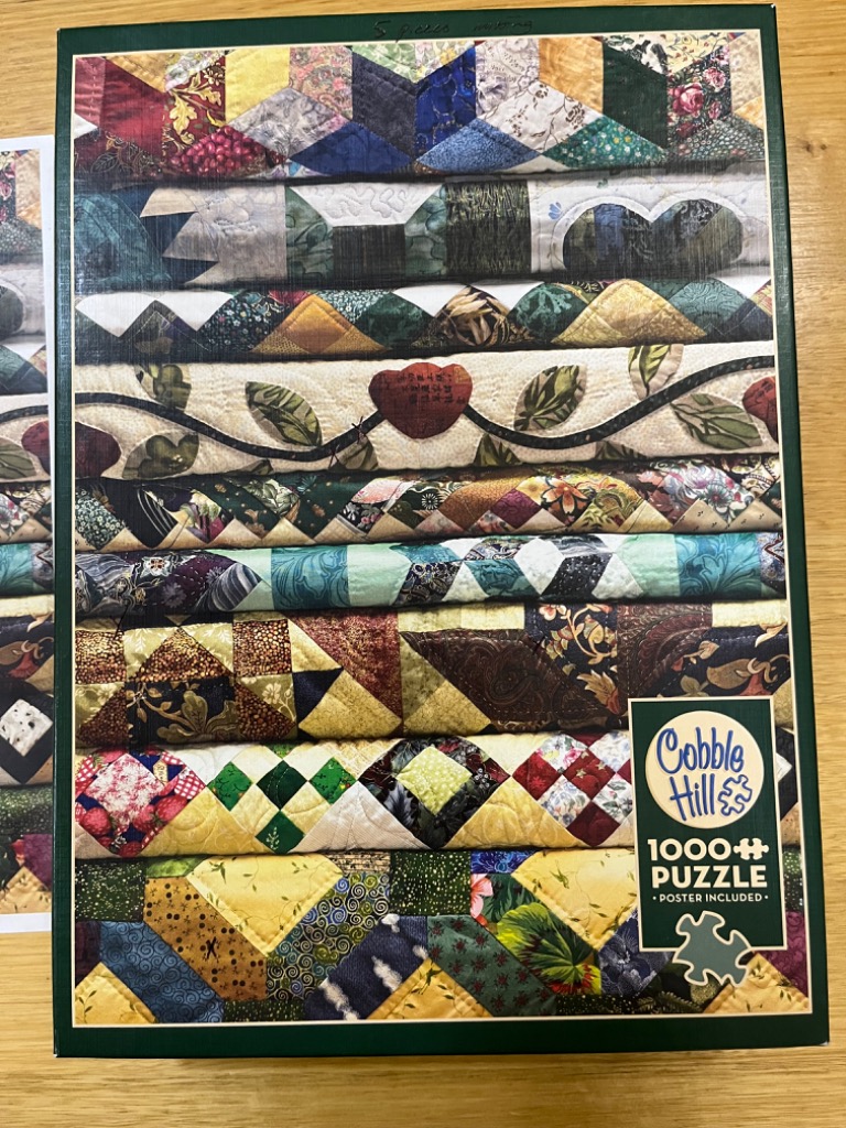 A stack of folded, colorful patchwork quilts with varied fabric patterns and textures.
