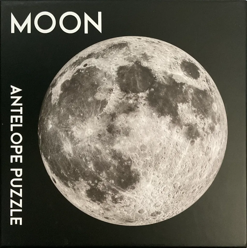 A high-contrast photograph of the full moon set against a solid black background.