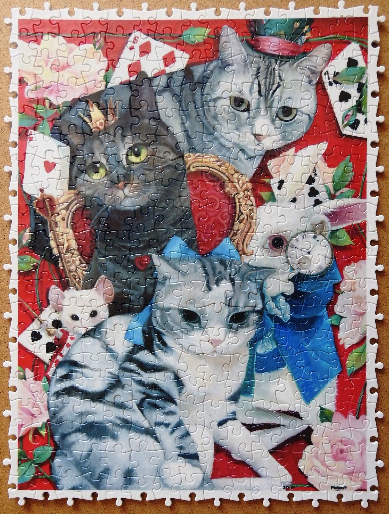 Alice in Wonderland themed illustration featuring several cats, a white rabbit, and playing cards against a bright red backgr