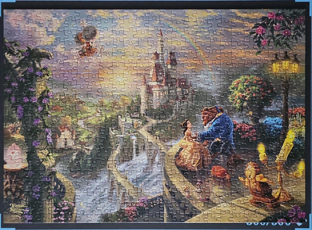 Belle and the Beast standing on a stone balcony before a castle with a rainbow in the sky