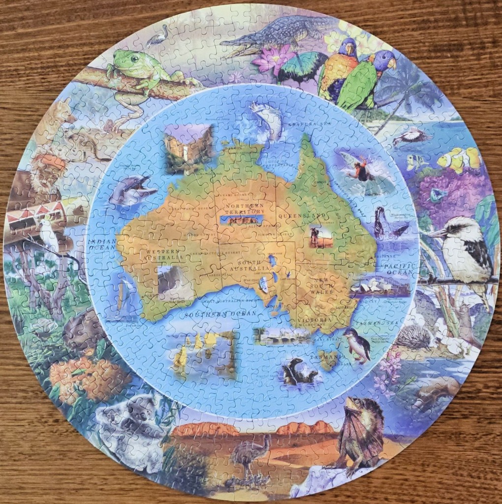 Circular illustration of a map of Australia surrounded by wildlife and iconic landmarks.