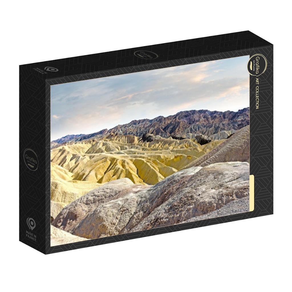 A panoramic landscape photograph of golden, mineral-rich desert badlands under a soft, overcast sky.