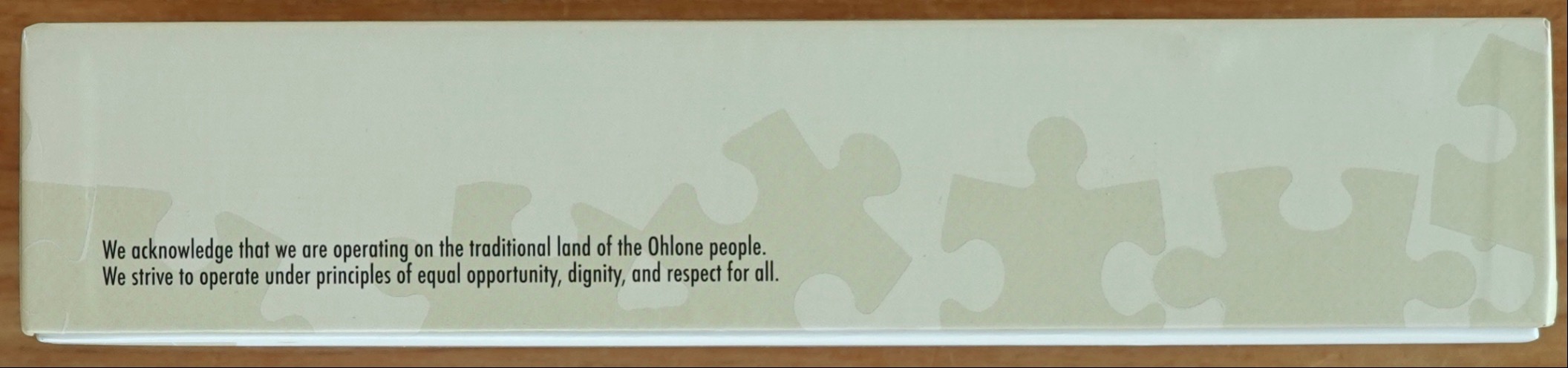Text statement about Ohlone land and principles of respect against a pale green background with ghosted puzzle pieces.