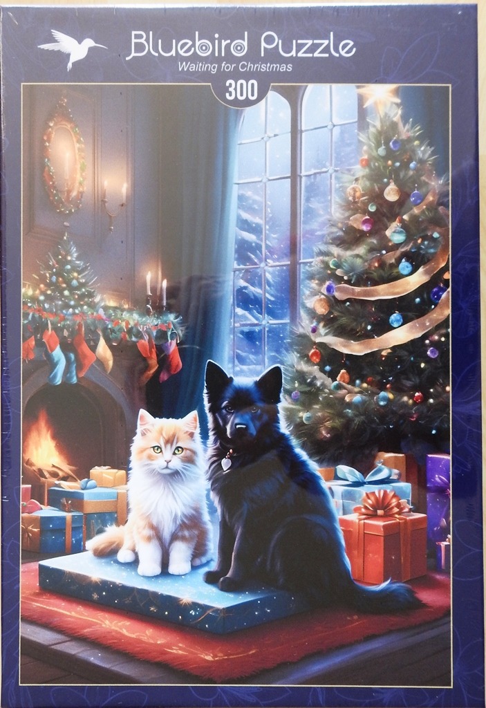 A ginger cat and a black dog sitting together on a wrapped gift in front of a Christmas tree.