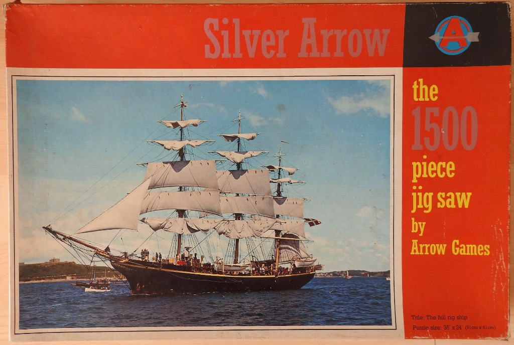 A classic full-rigged sailing ship with white sails on deep blue water near a coastline.