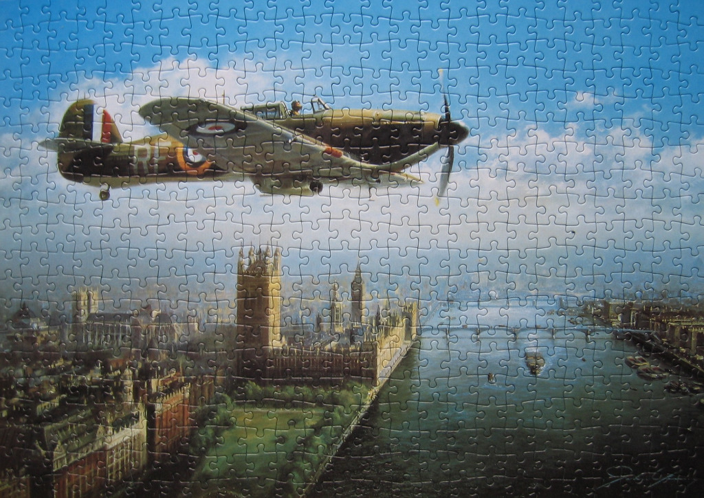 A vintage Hawker Hurricane fighter plane flying over the Houses of Parliament in London.
