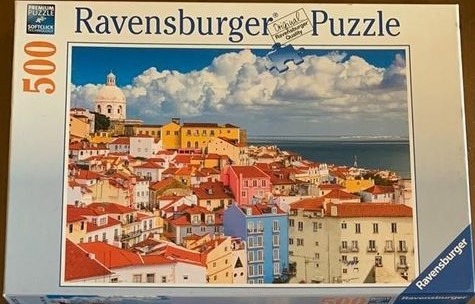 A scenic photograph of a Mediterranean coastal hillside city with orange-tiled roofs and a white domed church.