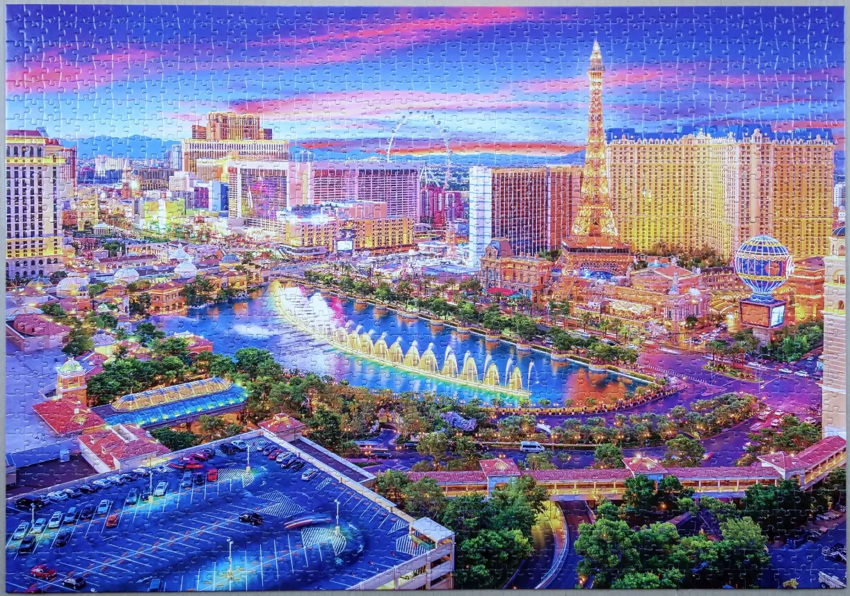 A panoramic twilight view of the Las Vegas Strip featuring the Bellagio fountains and the Paris Las Vegas Eiffel Tower.