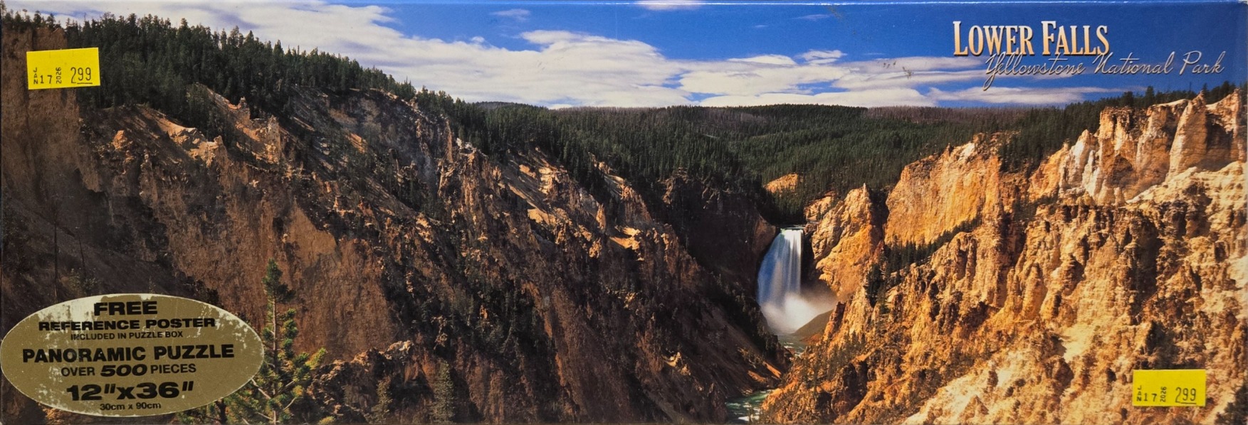 Panoramic photograph of Lower Falls in Yellowstone National Park surrounded by deep, rocky golden-hued canyons.