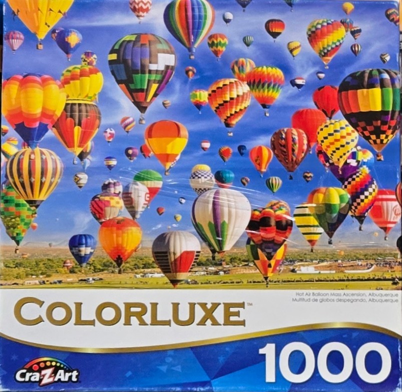 Many colorful hot air balloons floating in a clear blue sky above a desert landscape.
