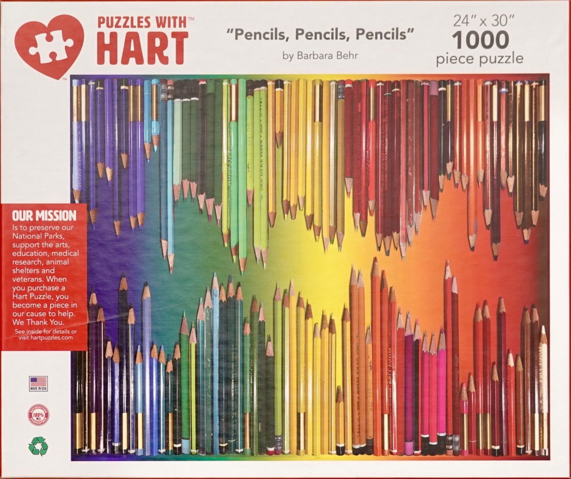 A collection of colored pencils arranged in a spectrum across the top and bottom of the frame.