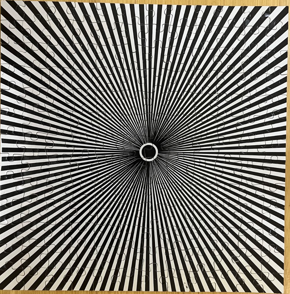 An optical art image of black and white lines radiating from a central white circle.
