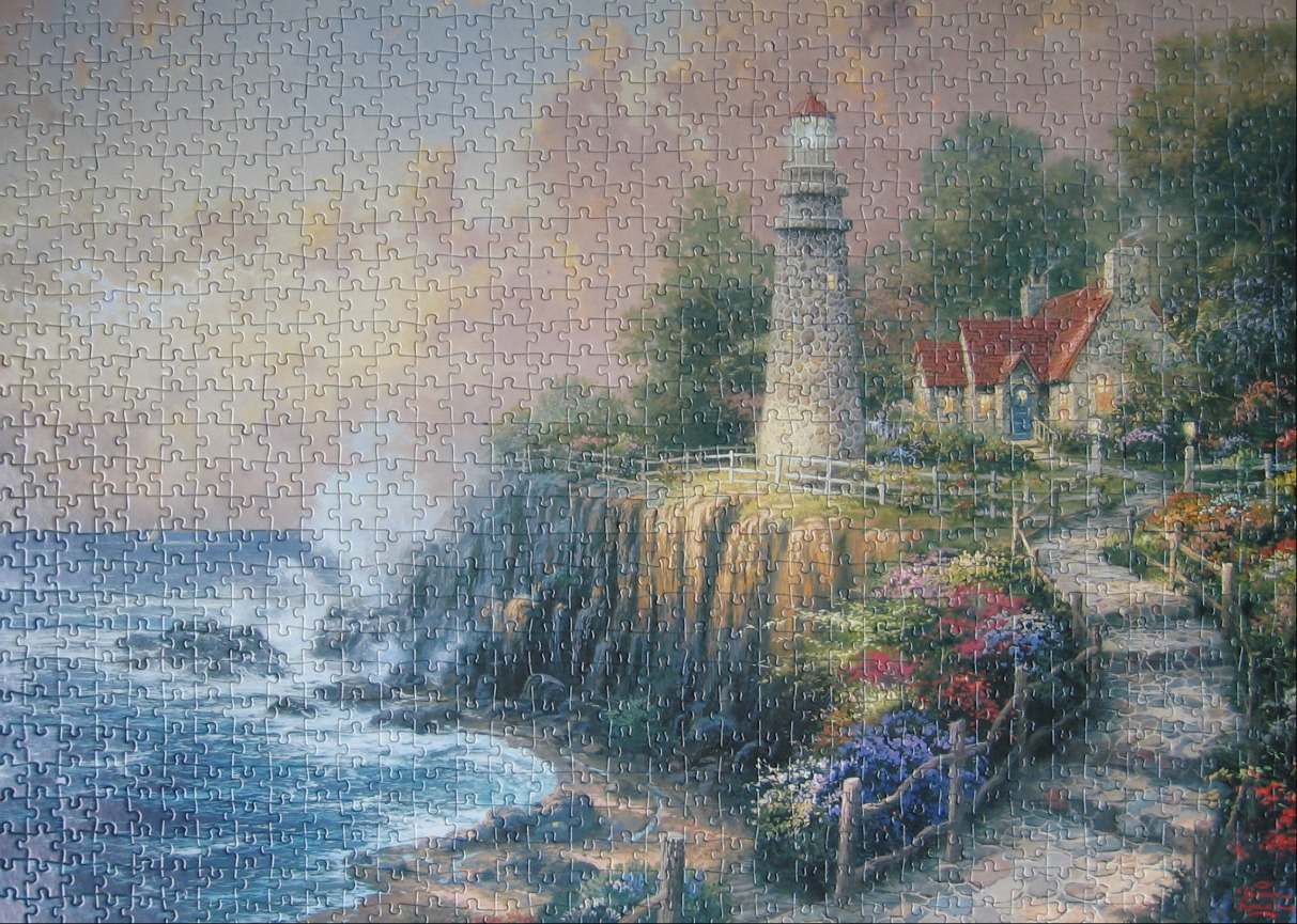A lighthouse and cottage on a coastal cliff at twilight.