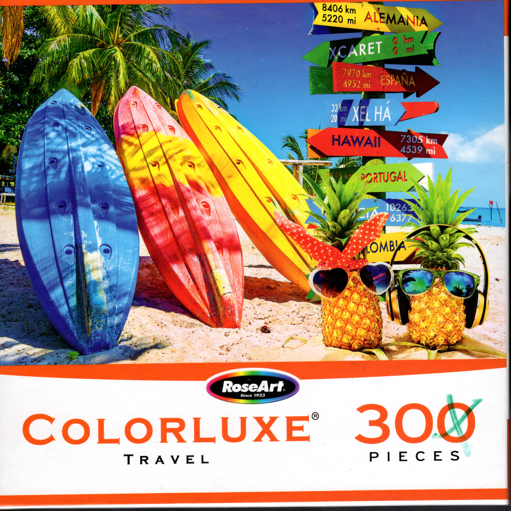 Three colorful kayaks leaning on a sandy beach next to two pineapples wearing sunglasses and tropical decor.