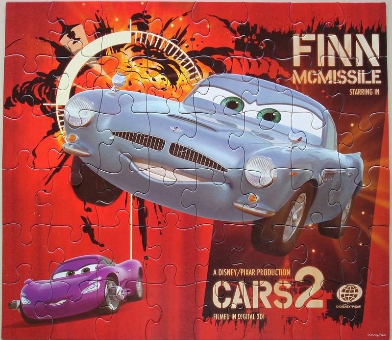 Finn McMissile from Cars 2 speeding against a red explosive background.