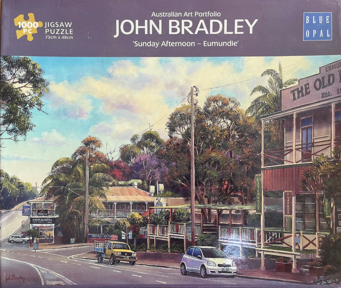 An oil painting of a peaceful street scene in Eumundie, featuring historic buildings, lush greenery, and parked cars.