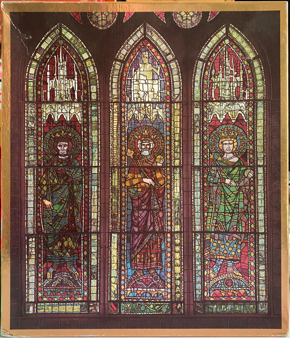 Stained glass artwork depicting three crowned medieval figures in arched windows.