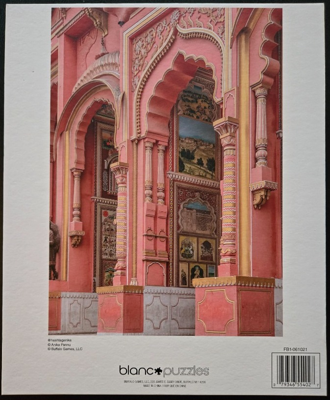 Ornate pink Indian architecture with painted panels and gold accents.