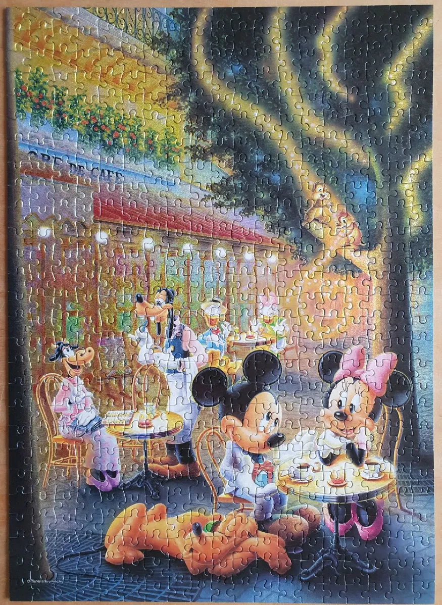 Disney characters dining at an outdoor cafe at night