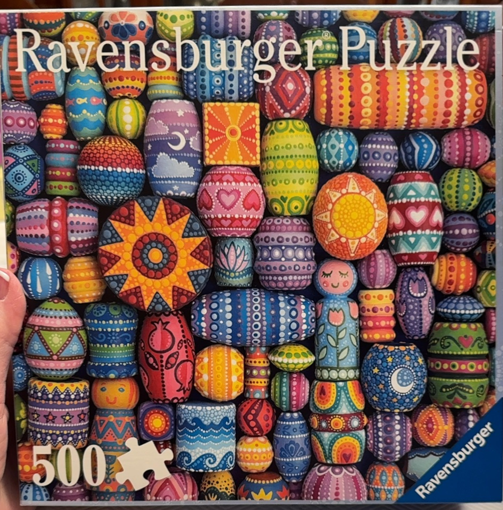 A dense, vibrant collection of hand-painted, colorful wooden beads and folk art figurines.