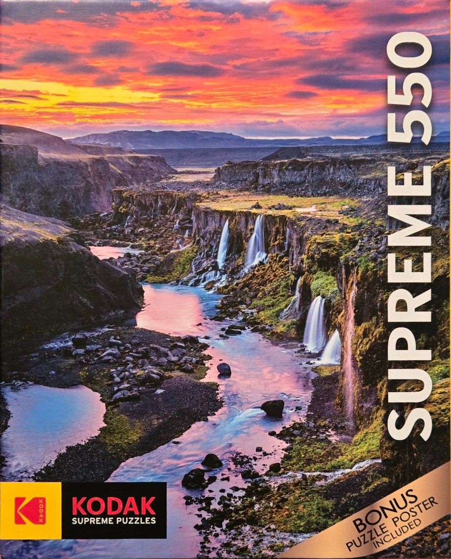 A dramatic sunset landscape featuring a river flowing between rocky cliffs with multiple waterfalls.