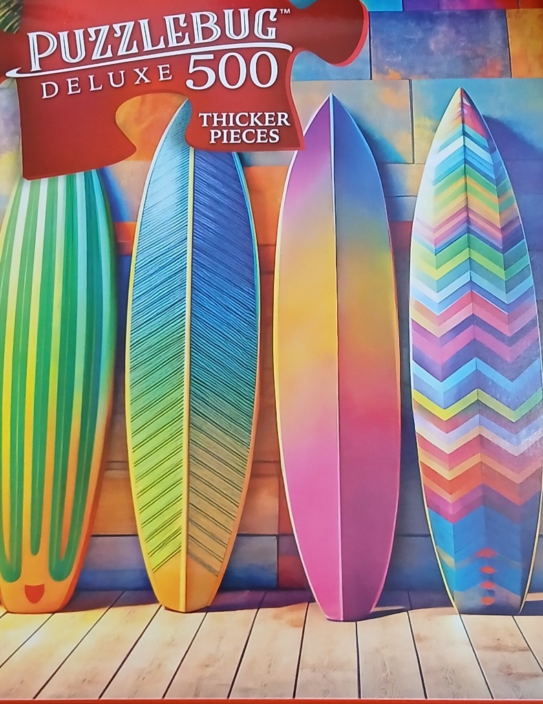 Four colorful surfboards leaning against a multicolored tiled wall on a wooden deck.
