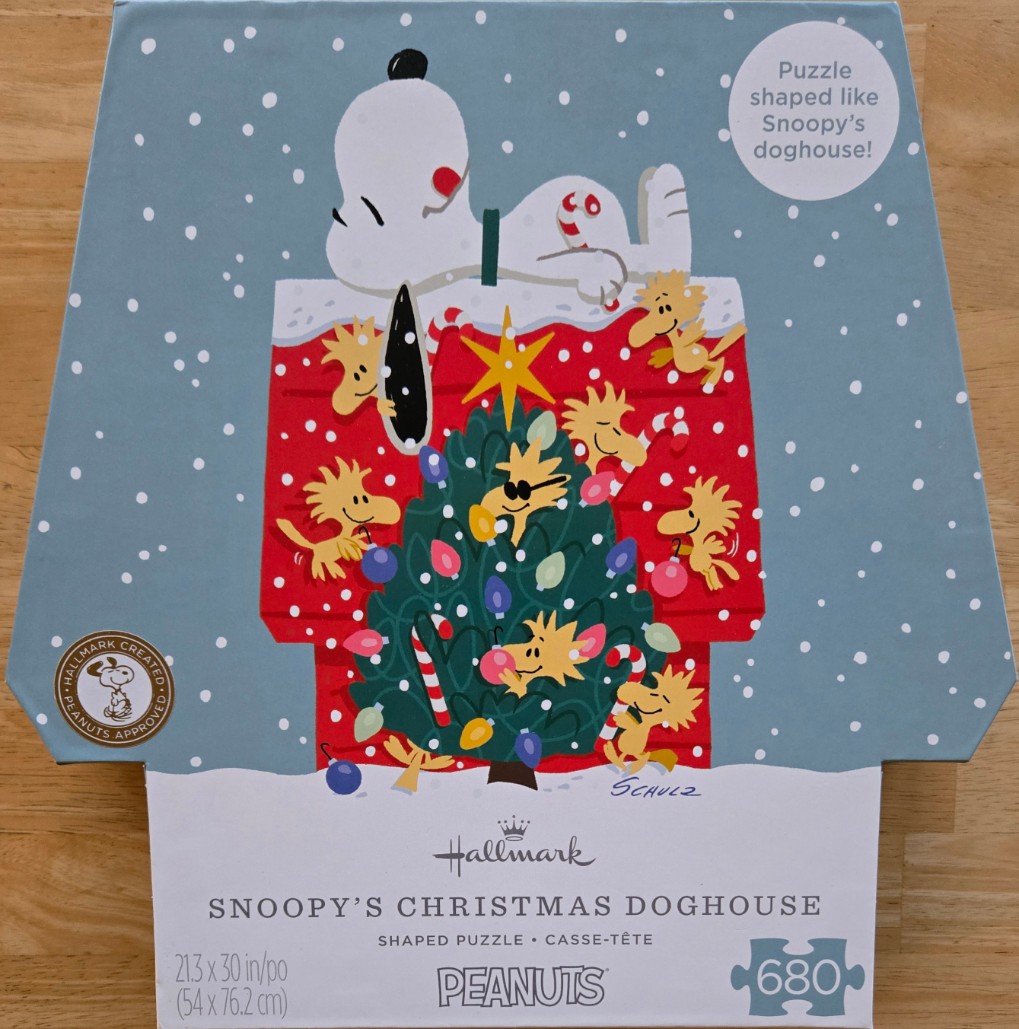 Snoopy and Woodstock decorating a Christmas tree on top of a red doghouse