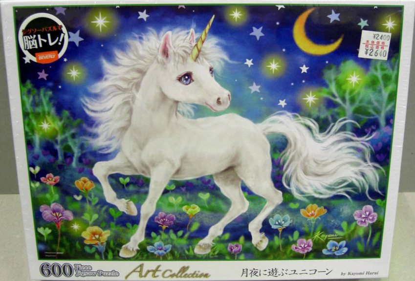 A white unicorn standing in a vibrant meadow under a moonlit night sky filled with stars.
