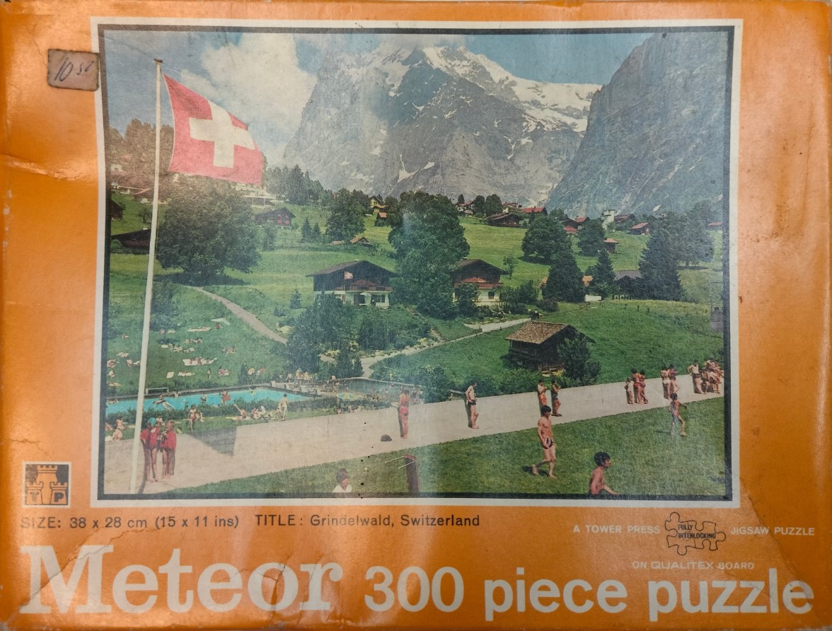 A vintage photograph showing a swimming pool in Grindelwald, Switzerland, with the Eiger mountain in the background.