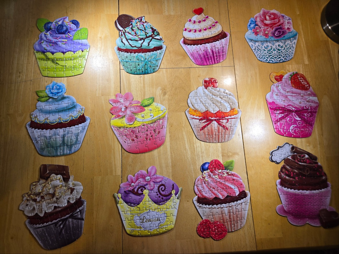 A collection of eleven diverse cupcake illustrations arranged on a wooden table.