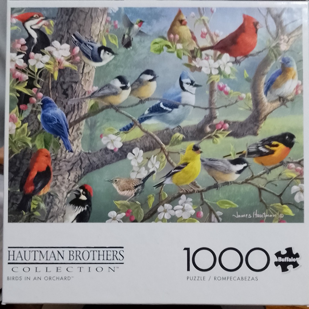 A collection of various North American songbirds perched on flowering apple tree branches.