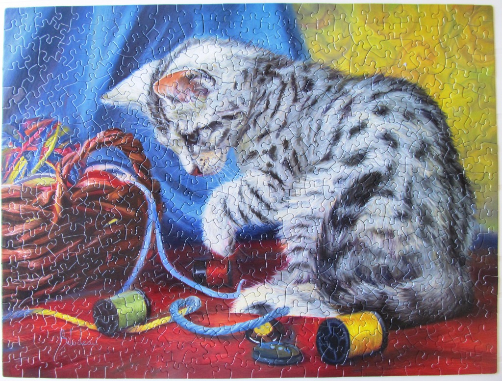 An oil painting of a grey tabby kitten playing with colorful sewing thread and spools.
