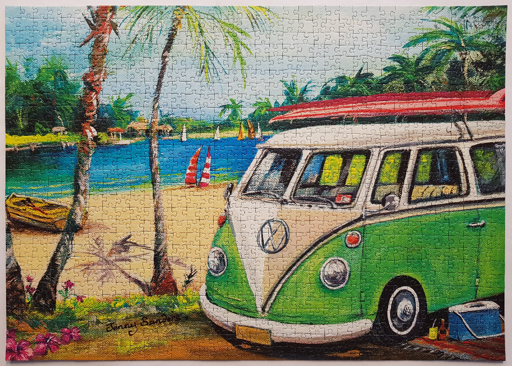 A green and white vintage van parked on a sandy beach with palm trees and a blue lagoon.