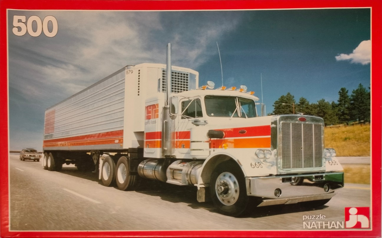 A white semi-truck with red and orange stripes driving on a highway.