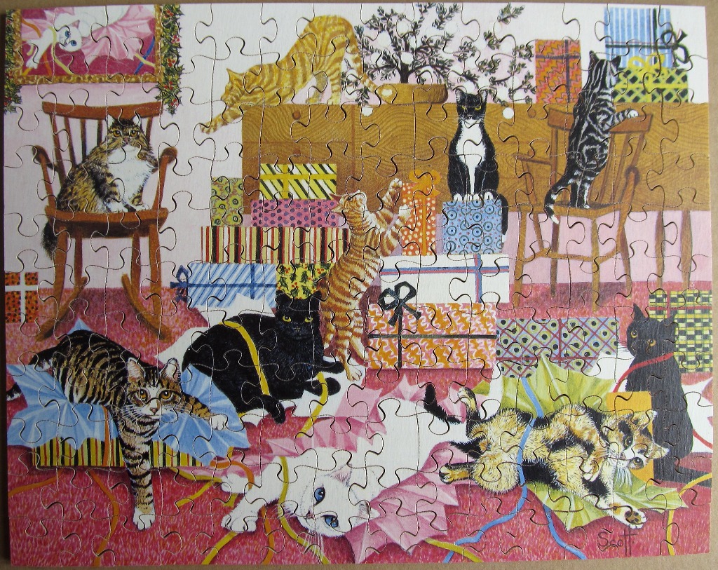 A whimsical illustration of many cats playing among colorful gift boxes in a room with a pink patterned carpet.