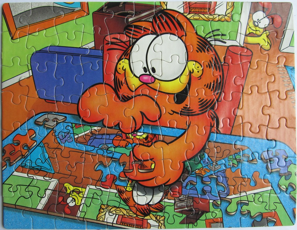 Garfield the cartoon cat looking down at a table showing a reflection of himself