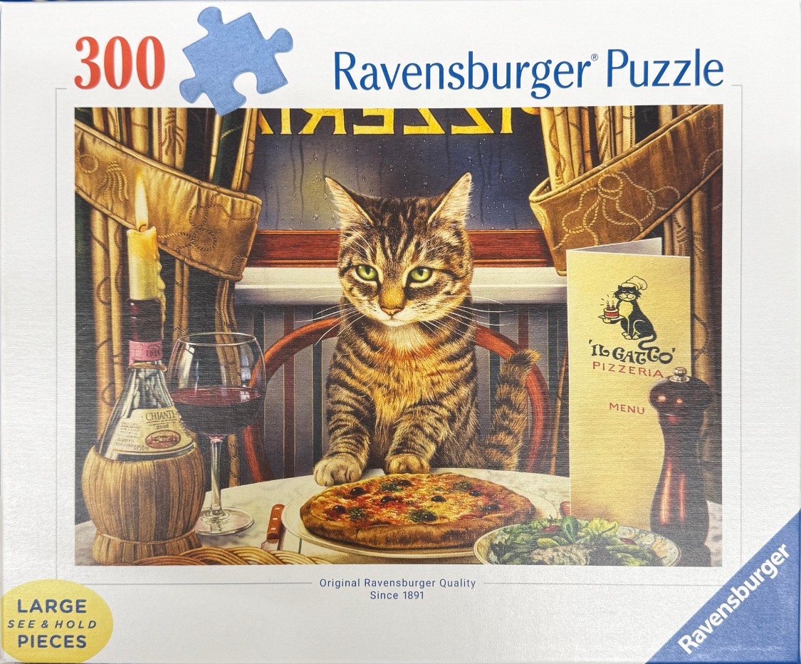 A tabby cat sits at a dinner table in a restaurant with a pizza, a bottle of wine, and a menu.