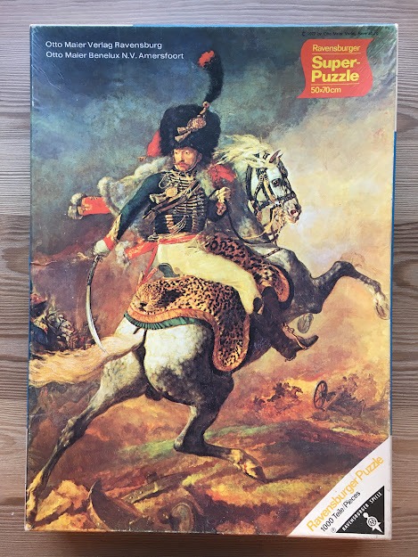 Painting of a 19th-century French cavalry officer on a rearing horse in a dramatic, smoke-filled battlefield.