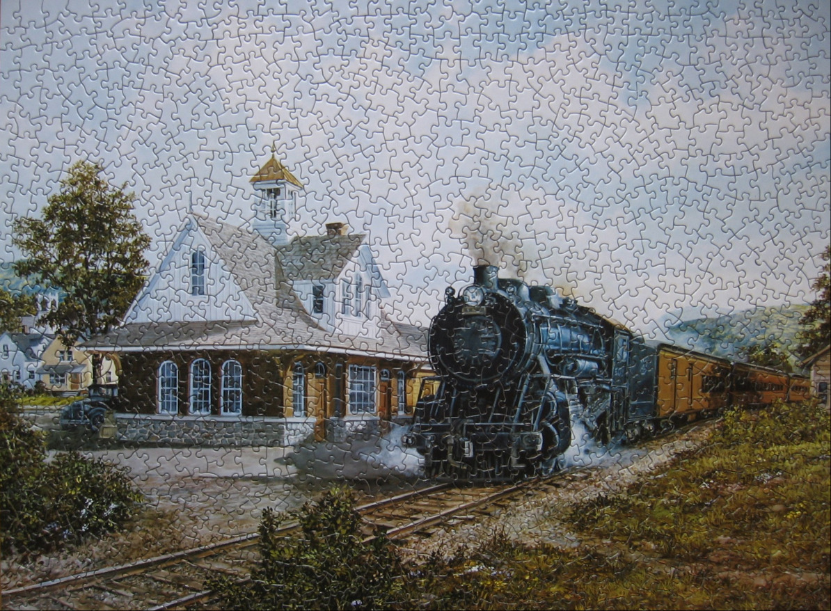 A black steam locomotive arriving at a quaint stone and wood train station on a clear day.