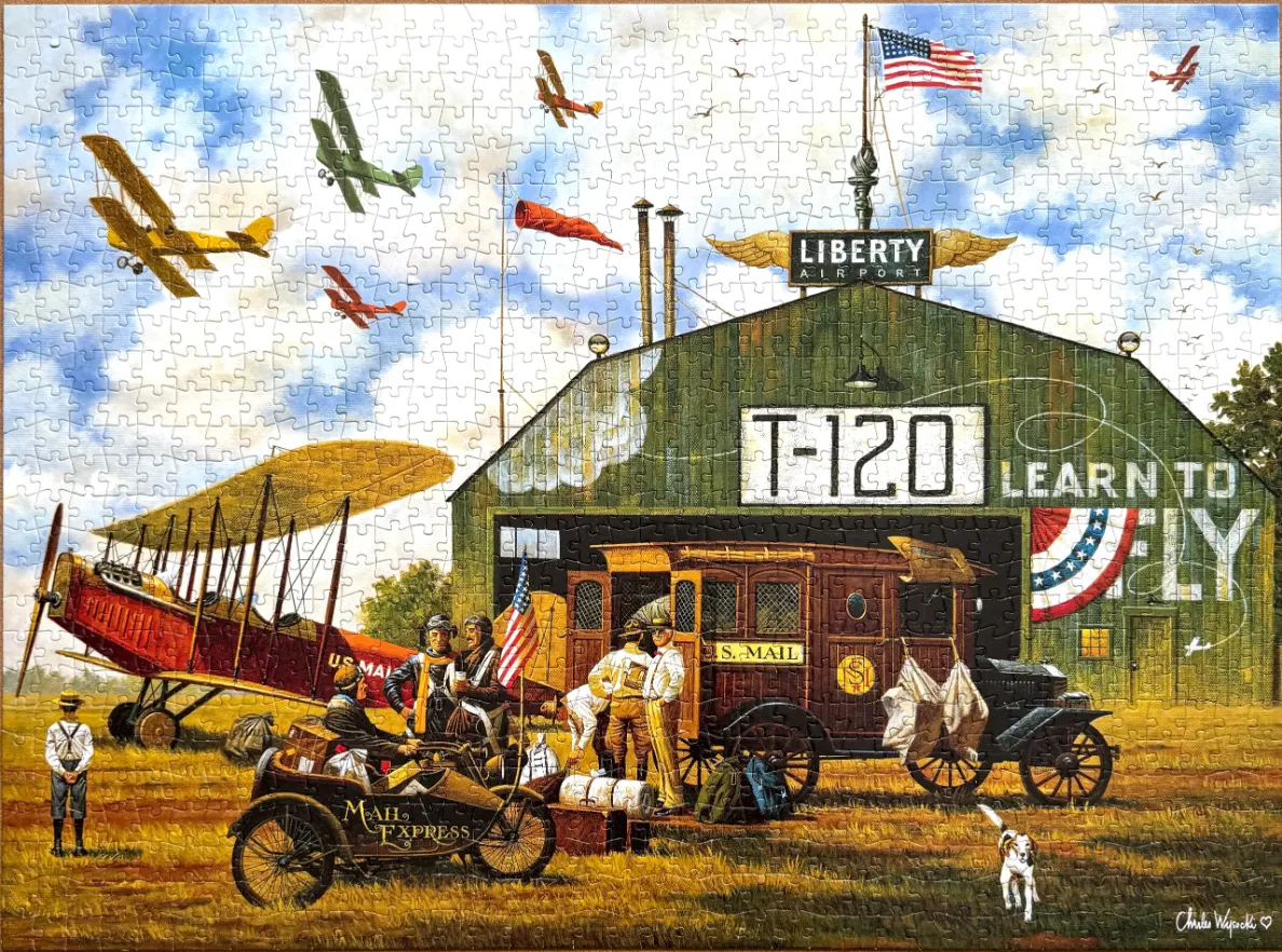 An illustration of an early 20th-century airfield hangar labeled Liberty Airport with vintage airplanes and mail trucks.
