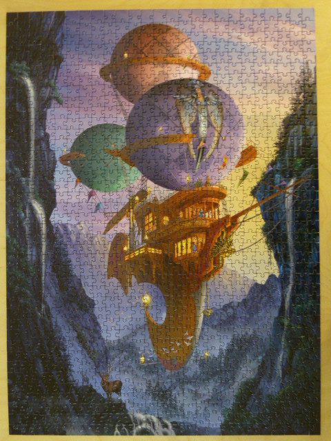A fantastical steampunk-style airship with large balloons floating through a rocky canyon.