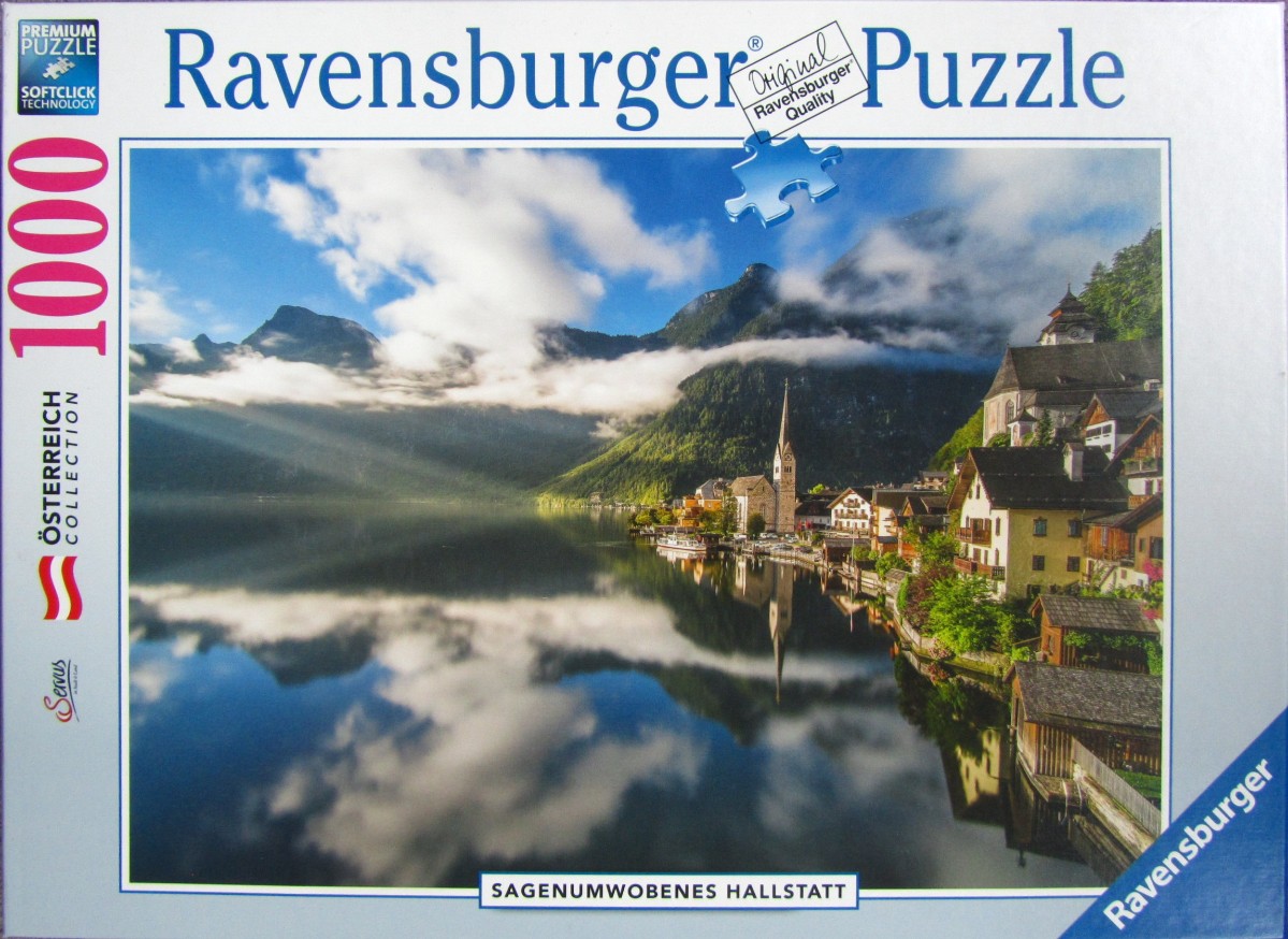 A scenic view of the village of Hallstatt, Austria, reflected in the calm waters of the lake with mountains in the back.