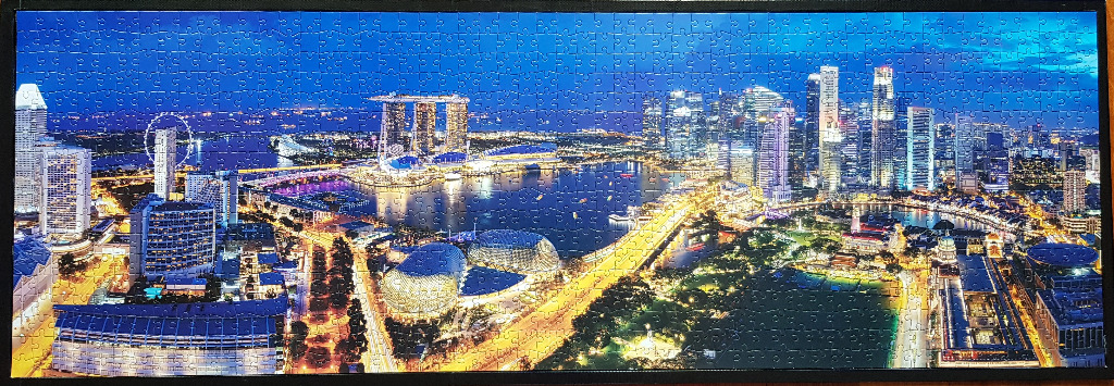 Panoramic night view of the Singapore skyline featuring the Marina Bay Sands resort and the illuminated cityscape.