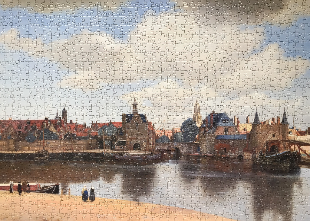 A reproduction of Vermeer's View of Delft showing the historic city skyline across a river with figures in the foreground.
