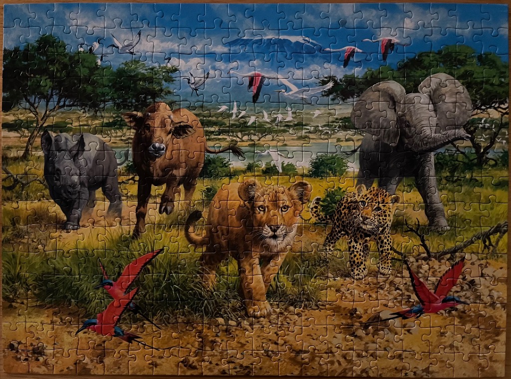 Illustration of various African wildlife in a savanna landscape under a cloudy blue sky.