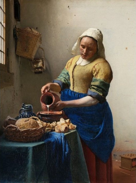 A kitchen maid pouring milk from a pitcher into a bowl on a table.