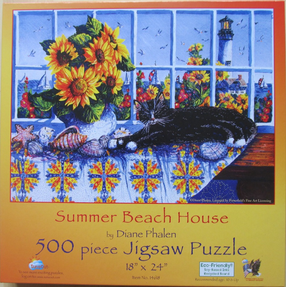 A black and white cat lies on a table covered by a quilt in front of a window showing a coastal scene with a lighthouse.