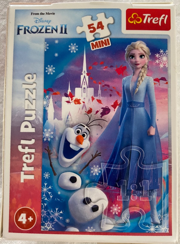 Elsa and Olaf from Frozen 2 standing in front of an ice palace with falling red autumn leaves and snowflakes.