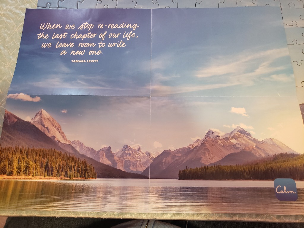 A scenic mountain lake landscape with a quote about new beginnings written in the sky.